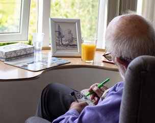 Sandalwood Court - resident sitting by window doing a crossword