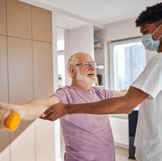 Carer helping elderly get dressed