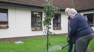 Plas Cae Crwn Care Home - resident watering plants in the garden