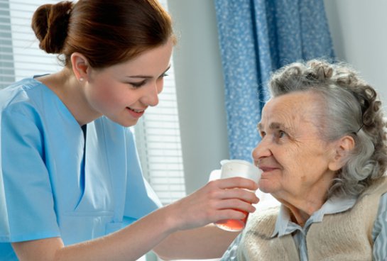 Agape Medical Health Care carer giving client a drink