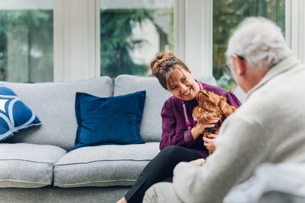 Home Instead Southampton Carer chatting with client on the sofa