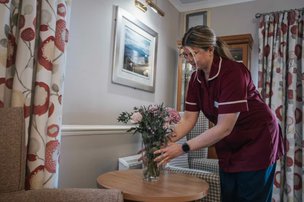 Kynnaird House, carer putting flowers down 