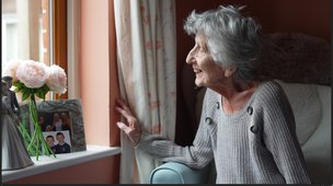 Mill River Lodge - Resident in bedroom looking out of her window
