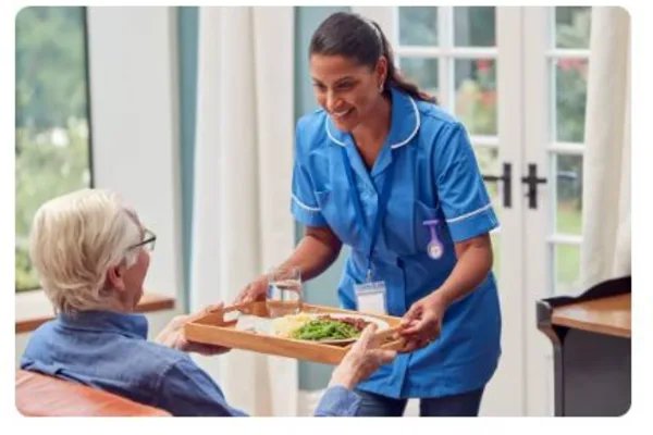 Cherish Social Care Live In, carer giving food to eldery man 