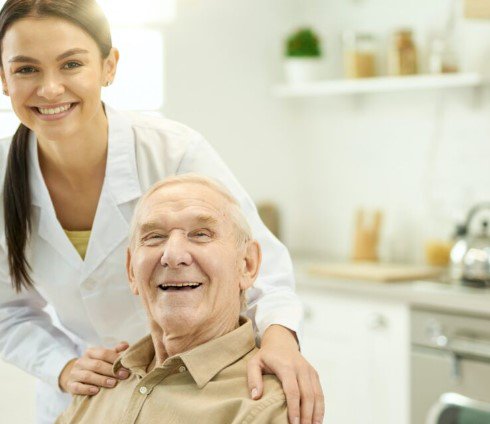 A G Supply Solutions, Nottingham. Carer with elderly man, hands on shoulders smiling  