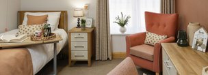 The Radley Care Home in Borehamwood, bedroom with arm chair 