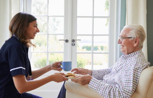 Braeburn Care Live in Care, carer giving elderly man tea. 