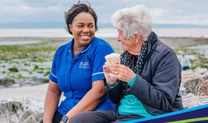 Caremark North Norfolk and Great Yarmouth, carer with client at the beach 