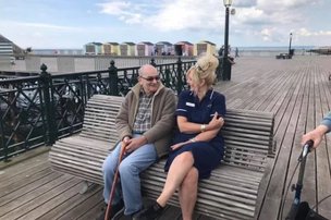 Crest House, St Leonards-on-Sea. Carer sitting with elderly man on the pier. 