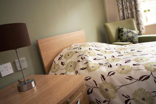 De Brook Lodge, bedroom with green chair 