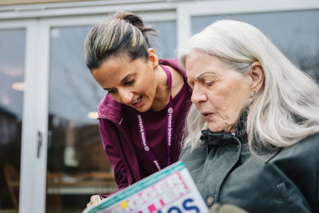 Home Instead Calderdale Live in, carer with client reading