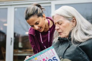 Home Instead Calderdale, carer with client reading