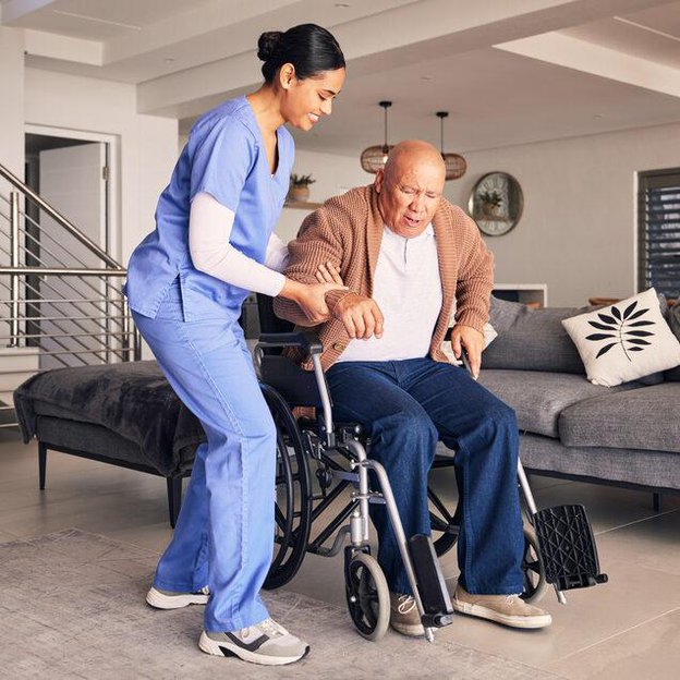 Adefey Group carer helping gentleman out of wheelchair