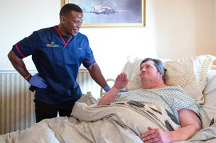 Millfield Healthcare Services, carer helping eldery man in bed 