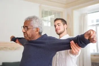 1st Focus Homecare, helping eldery man stretch his arms 