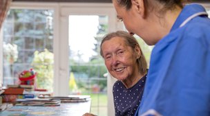 Bluebird Care Hounslow & Chiswick living carer by the dining table with client