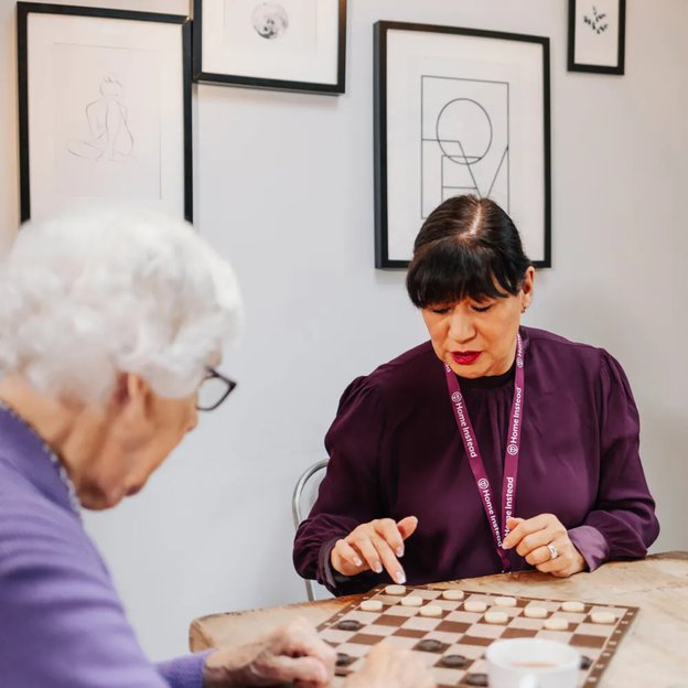 Home Instead Salford and Worsley carer playing game with client