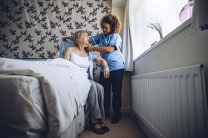 Oxford House Community Care in Slough carer helping woman dress