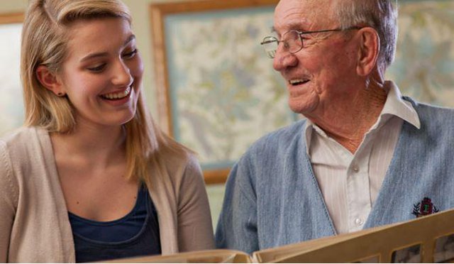 Home Instead Home Care in Welwyn Garden City younger lady reading with elderly man