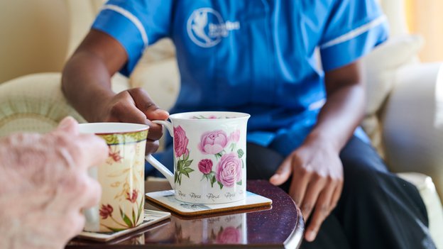 Bluebird Care Pontypridd carer having tea with client