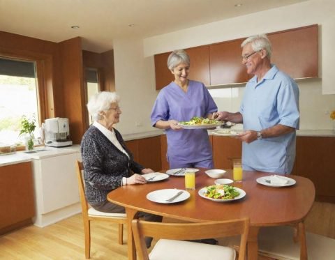 Anglia Prime Care, Sheffield, carer at table with eldery people 