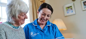 Bluebird Care Hounslow & Chiswick carer reading with client