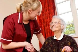 Meridian Community Care, carer holding elderly ladys hand. 