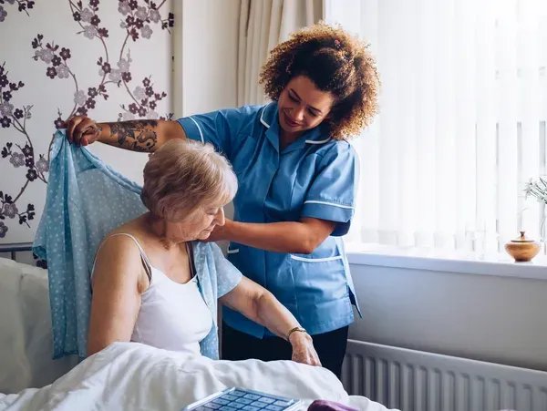 Paddle Healthcare, Dunstable Carer helping elderly lady dressing 