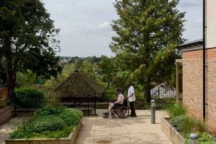 Highfield House, carer with resident in the garden. 