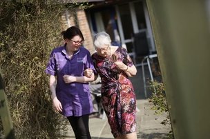 Pilgrims View, Snodland. Carer walking with resident. 