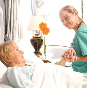 Profound Care, carer holding elderly ladys hand. 