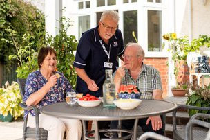 Radfield Home Care Bath, Keynsham & Radstock. Carer with eldery people sitting in the garden 