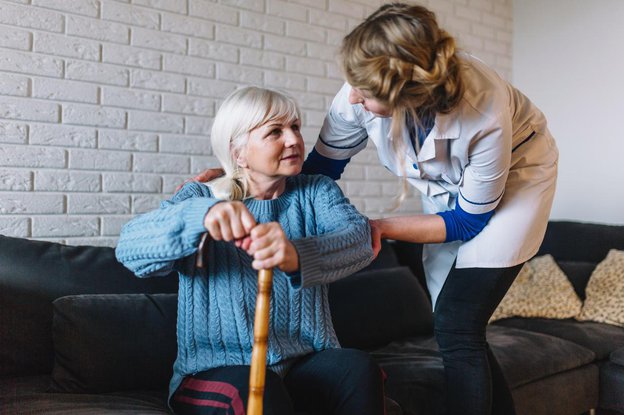 Wellslane South Yorkshire, Carer helping eldery on the sofa