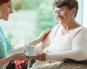 Twinlight Healthcare, Manchester, carer giving a cup of tea to lady 