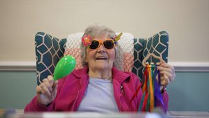 The Grove Care Home - resident with sunglasses and maracas