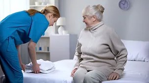 St Annes Nursing Home. Female resident sitting on bed 