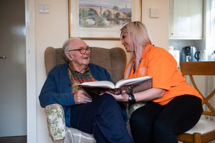 Sylvian Care Southampton, carer with elderly man sitting in chair. 
