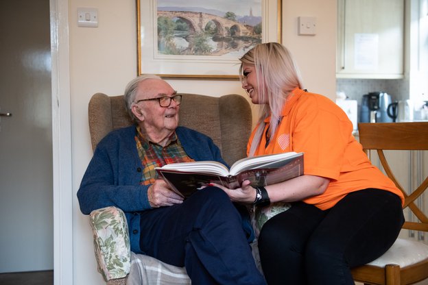 Sylvian Care South Gloucester. Carer reading to elderly man. 