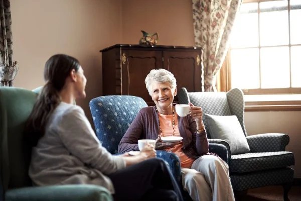 Visiting Angels Central Surrey, carer with eldery female having a cup of tea. 