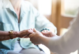 Visiting Angels Stirlingshire carer and client holding hands